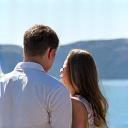 Sarah and Mark posing on a stunning cliffside viewpoint in Greece.